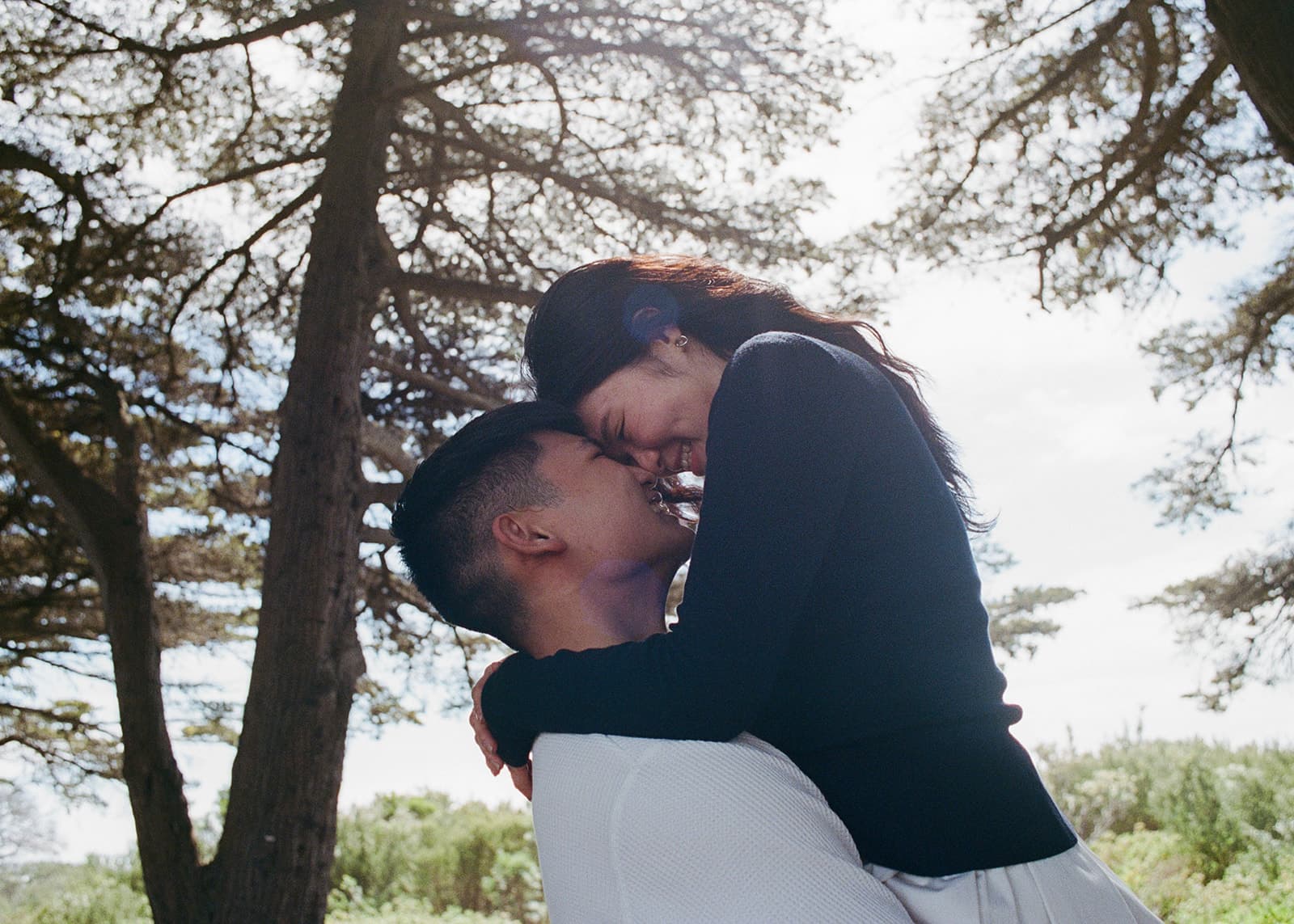 Chesqa and Kobe kissing under a tree